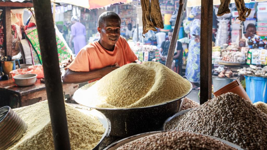 A trader waits for costumers while selling grains, legumes and flours in his stall at a market in the Obalende area of Lagos on December 18, 2023. [Getty Images]