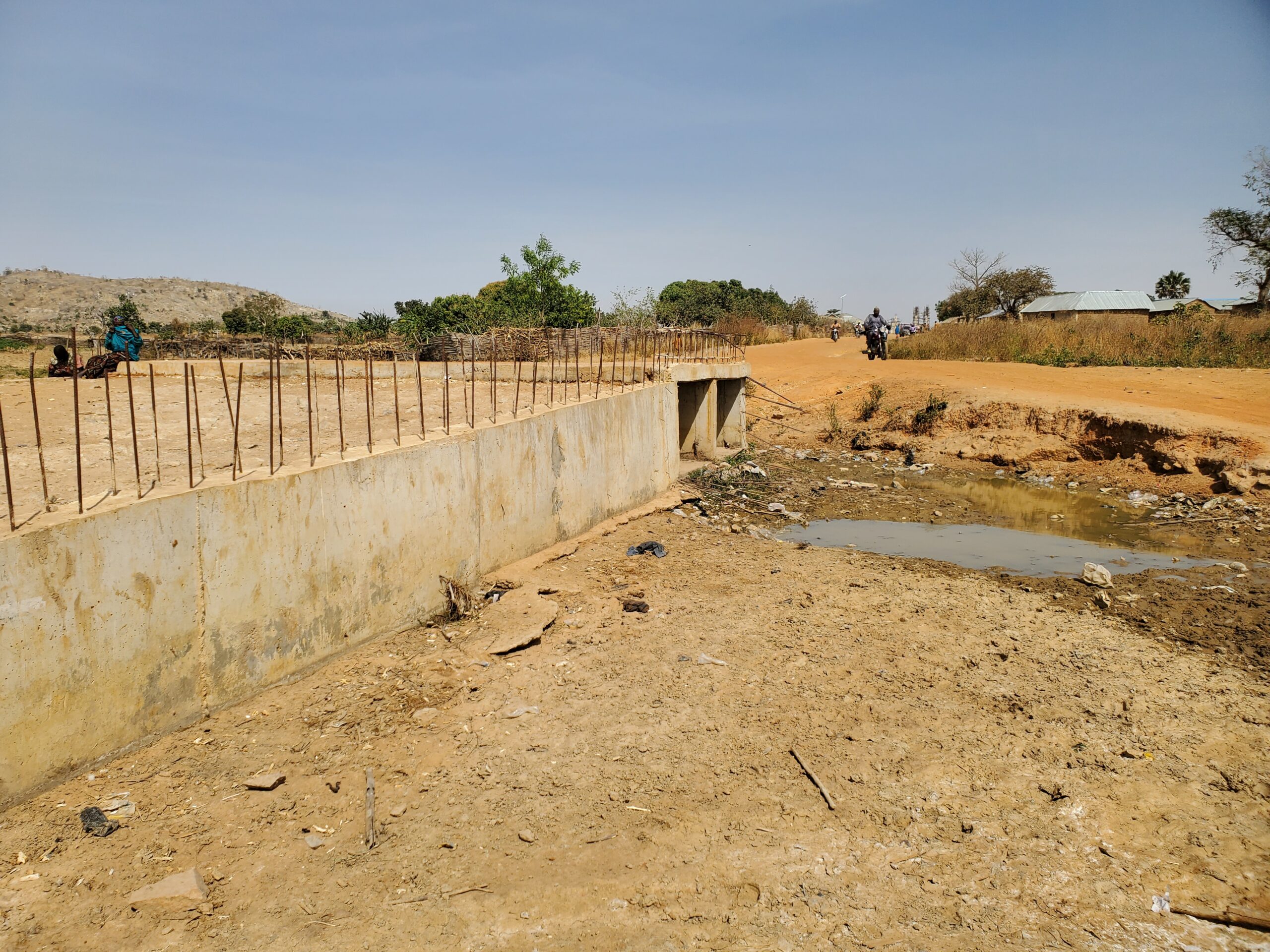 An abandoned bridge culvert that channels water across the road leading to the farm settlement. Photo Source: Cole Praise/DUBAWA.