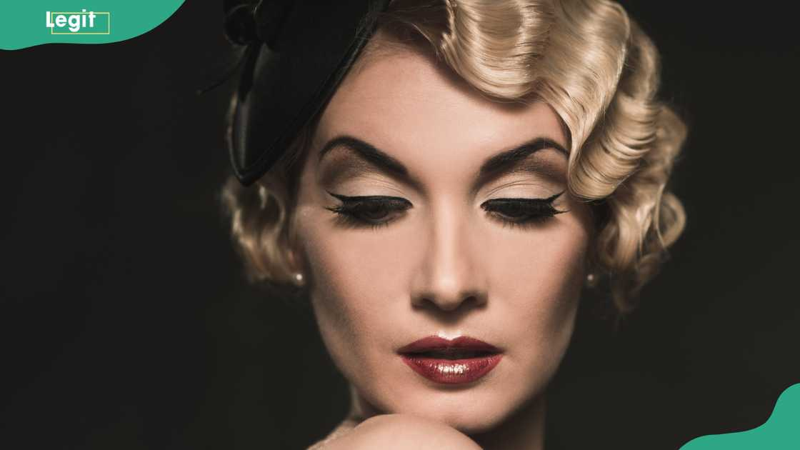 Elegant blond retro woman wearing little hat with beautiful hairdo and red lipstick