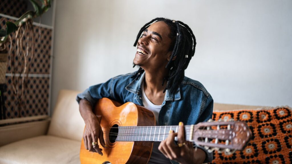 happy man playing guitar to lower stress